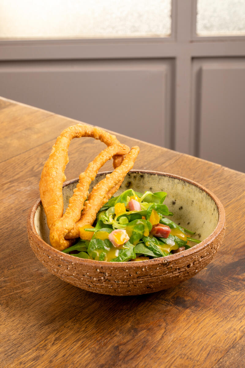 Spinach salad with orange and lalagia (fried dough strips)